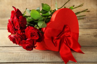 Sevgililer günü hediye kutusu eski ahşap masa üzerinde kırmızı Güllü kalp şeklinde