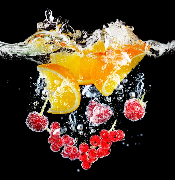 Frutta fresca e bacche spruzzando in acqua su sfondo nero — Foto Stock