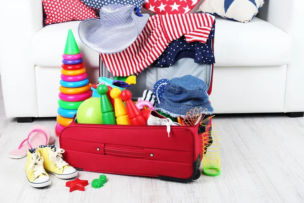 Suitcase packed with clothes and child toys