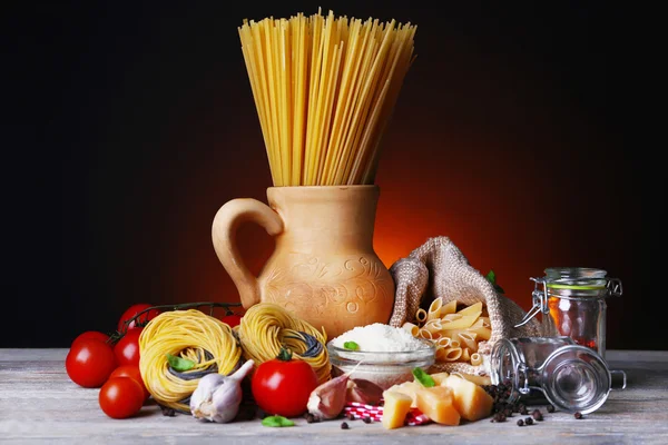 Pasta con pomodorini e altri ingredienti su sfondo scuro colorato — Foto Stock