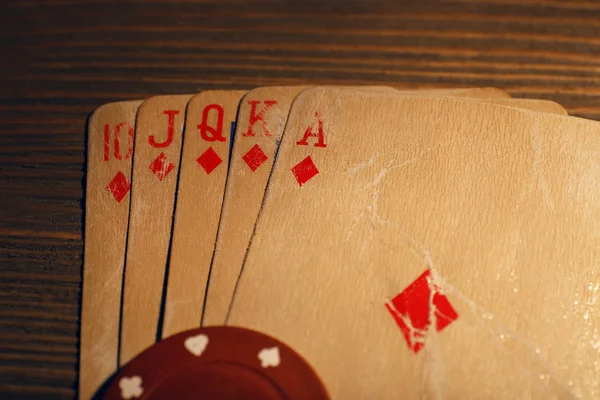 Speelkaarten met chips op houten tafel, close-up — Stockfoto