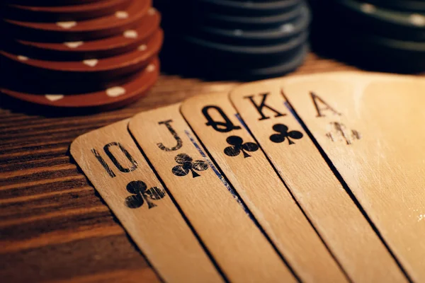 Игральные карты с чипсами на деревянном столе, крупный план — стоковое фото