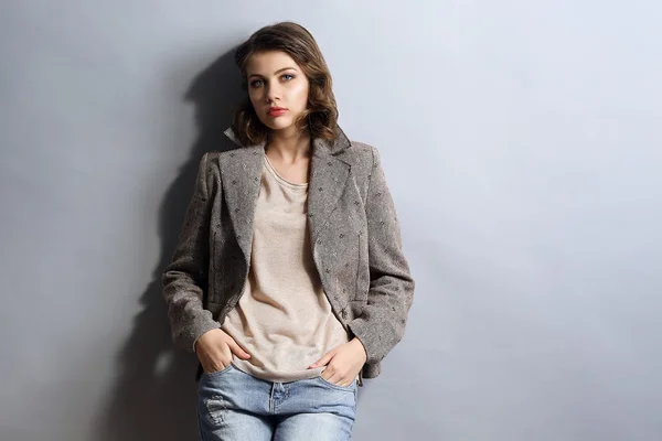 Retrato de modelo hermoso en jeans y chaqueta sobre fondo gris —  Fotos de Stock