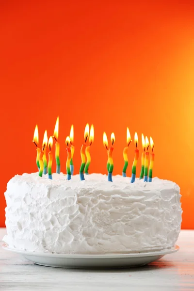 Torta di compleanno con candele su sfondo a colori — Foto Stock