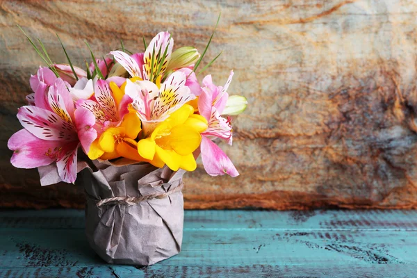 Красивые цветы в вазе на деревянном фоне — стоковое фото