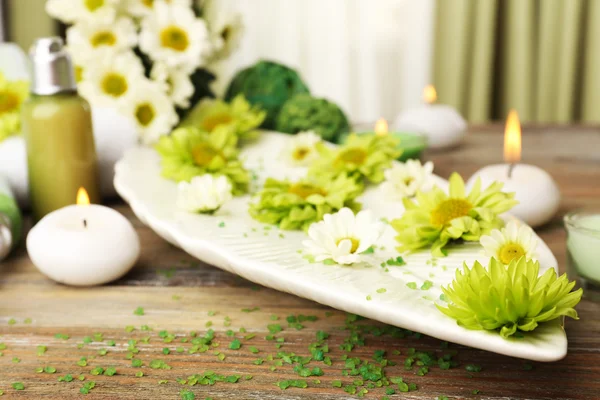 Kerzen mit Blumen auf Teller auf dem Tisch in Großaufnahme — Stockfoto