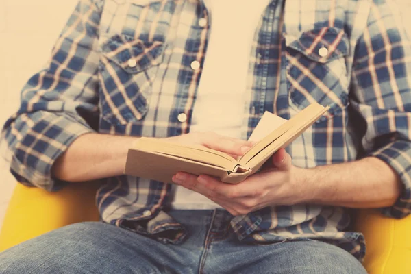 Jonge man lezen boek, close-up, op lichte achtergrond — Stockfoto