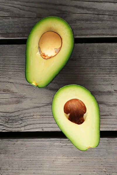 Sliced avocado on wooden background — Stock Photo, Image