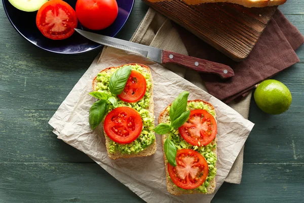 Panino vegano con avocado e verdure su sfondo di legno — Foto Stock