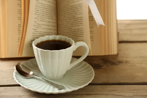 Natureza morta com xícara de café e livro, em mesa de madeira — Fotografia de Stock