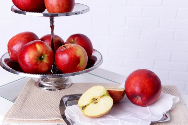 Tasty ripe apples on serving tray on brick wall background — Stock Photo, Image