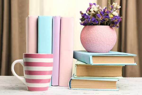 Livres, gobelets et plantes sur table en bois, gros plan — Photo