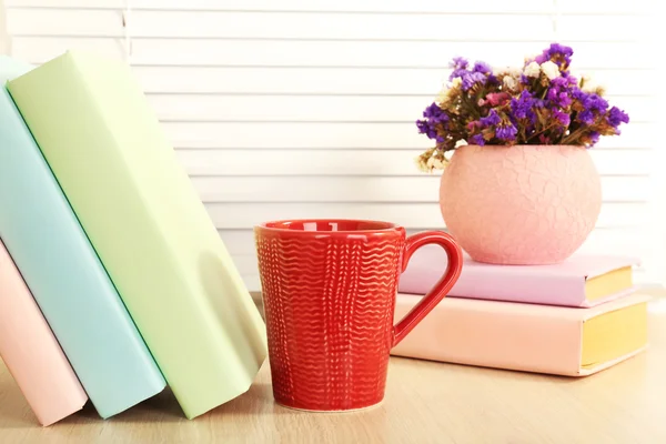 Books, cup and plant on wooden windowsill, closeup — Stock Photo, Image