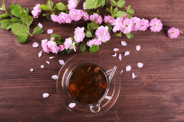 Cup of herbal tea with pink roses on wooden table, top view — Stock Photo, Image