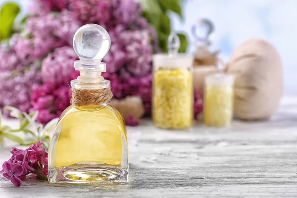 Sea salt, flowers and spa treatment on color wooden table, on light background — Stock Photo, Image