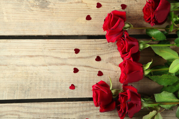 Beautiful red roses on old wooden table