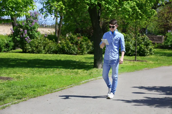 Muž se sluchátky v parku — Stock fotografie