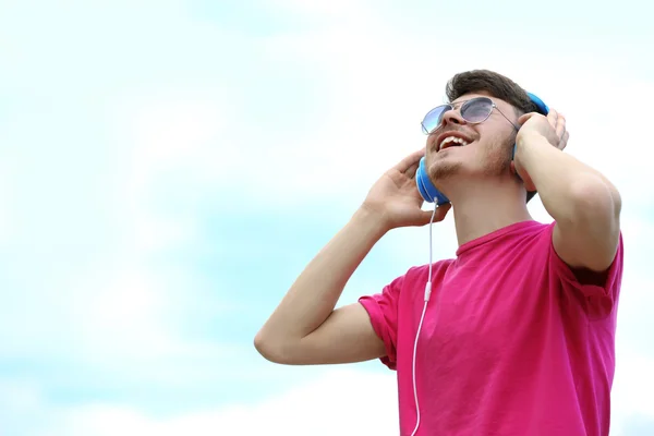 Man met hoofdtelefoon op blauwe hemelachtergrond — Stockfoto