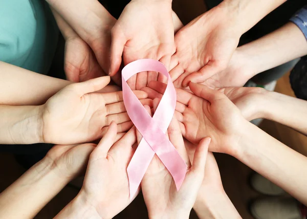 Grupo de manos femeninas con cinta rosa como símbolo de conciencia del cáncer de mama, primer plano — Foto de Stock
