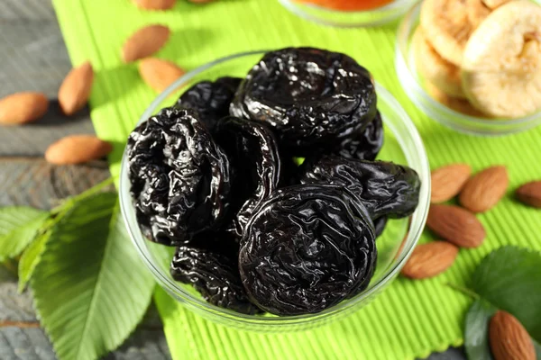 Dried fruits and almonds with leaves on green napkin, closeup — Stock Photo, Image