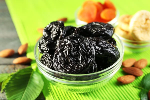 Dried fruits and almonds with leaves on green napkin, closeup — Stock Photo, Image