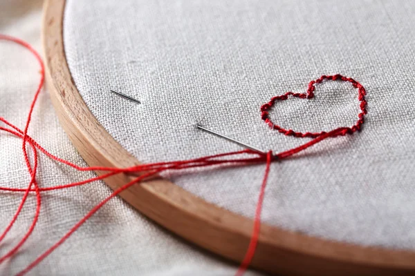 El aro de bordado con tela e hilos de coser rojos en la mesa de cerca — Foto de Stock