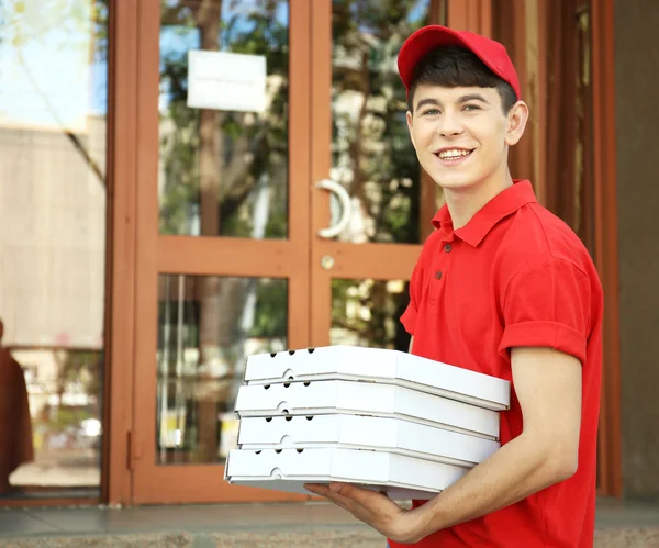 Giovane uomo consegna pizza box vicino a casa — Foto Stock