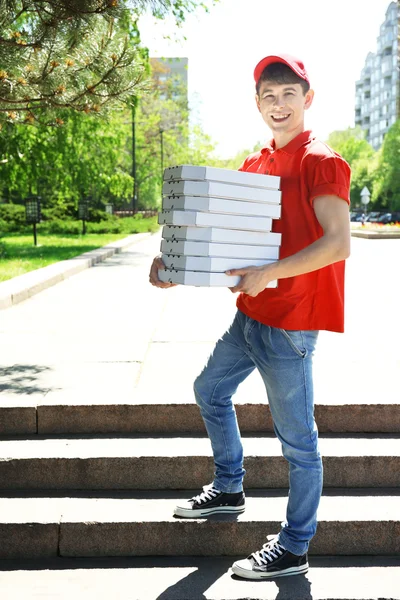 Jonge man leveren pizzadoos buitenshuis — Stockfoto