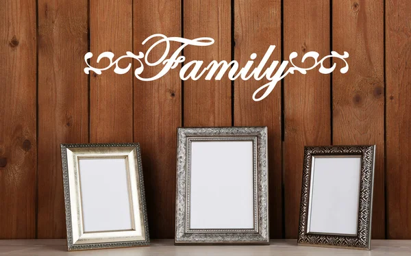 Photo frames on wooden surface, on wooden wall background — Stock Photo, Image
