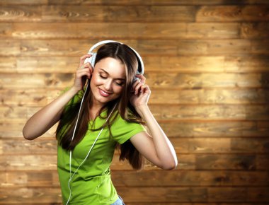 ahşap arka plan kulaklıktan olan kadın