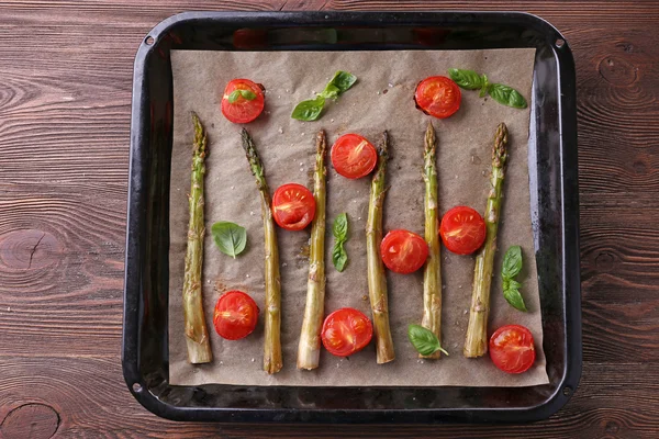 Geroosterde asperges met tomaten en greens op tafel close-up — Stockfoto