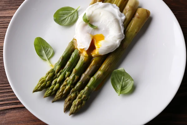 Gebratener Spargel mit pochiertem Ei auf Teller aus nächster Nähe — Stockfoto