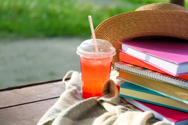 Books, hat and drink outdoors — Stock Photo, Image