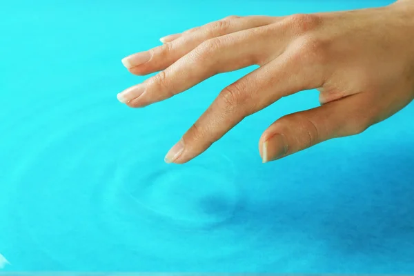 Mano femminile toccare superficie dell'acqua — Foto Stock