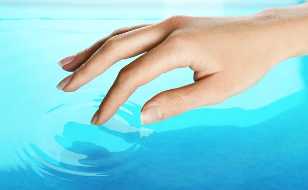 Main féminine touchant la surface de l'eau — Photo