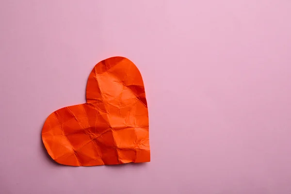 Corazón de papel arrugado sobre fondo rosa — Foto de Stock