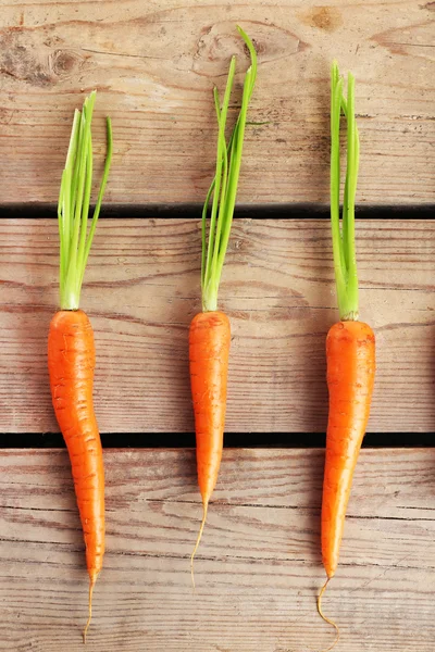 Carottes fraîches sur fond de planches de bois — Photo