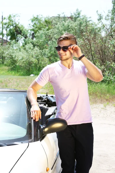 Jeune homme debout près du cabriolet, à l'extérieur — Photo