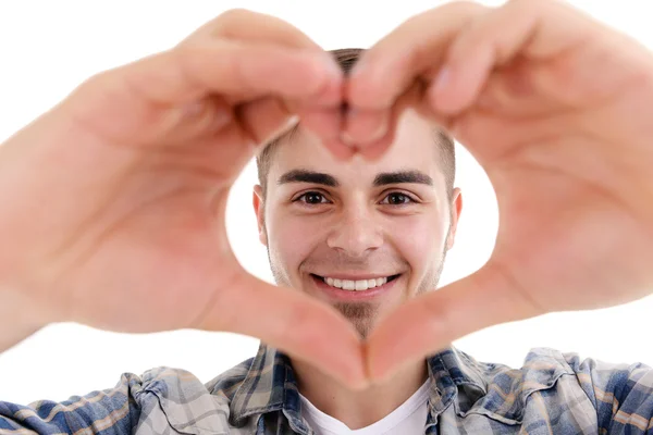 Lächelnder attraktiver junger Mann macht Herz mit Fingern — Stockfoto