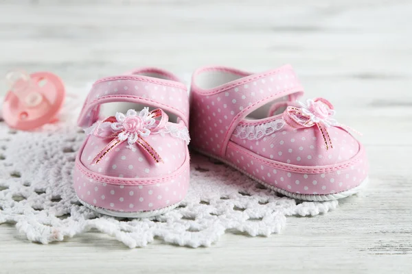 木製の背景のピンクの幼児の靴 — ストック写真