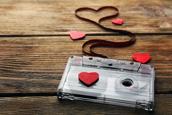 Cassette de audio con cinta magnética en forma de corazón sobre fondo de madera — Foto de Stock