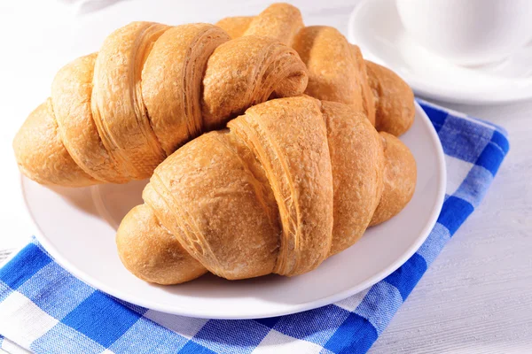 Delicious croissants on plate on table close-up — Stock Photo, Image