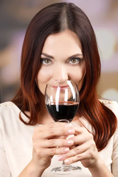 Jovem mulher degustação de vinho no fundo brilhante — Fotografia de Stock