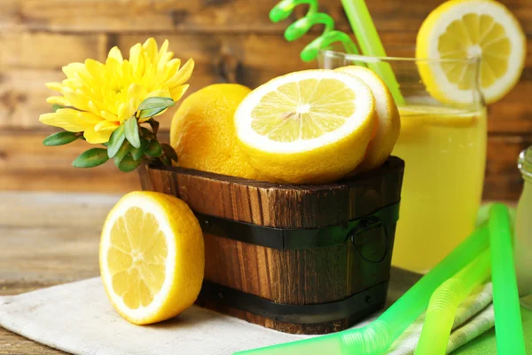 Bodegón con jugo de limón y limones en rodajas sobre fondo de madera — Foto de Stock