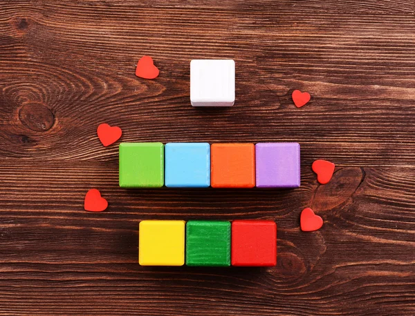 Colorful cubes for inscriptions on wooden background — Stock Photo, Image