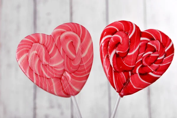 Bright lollipops in shape of heart on wooden background — Stock Photo, Image