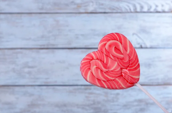 Bright lollipop in shape of heart on wooden background — Stock Photo, Image