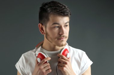 yakışıklı genç gri arka plan üzerinde kulaklık ile