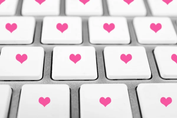 Close up of laptop keyboard with hearts icons — Stock Photo, Image