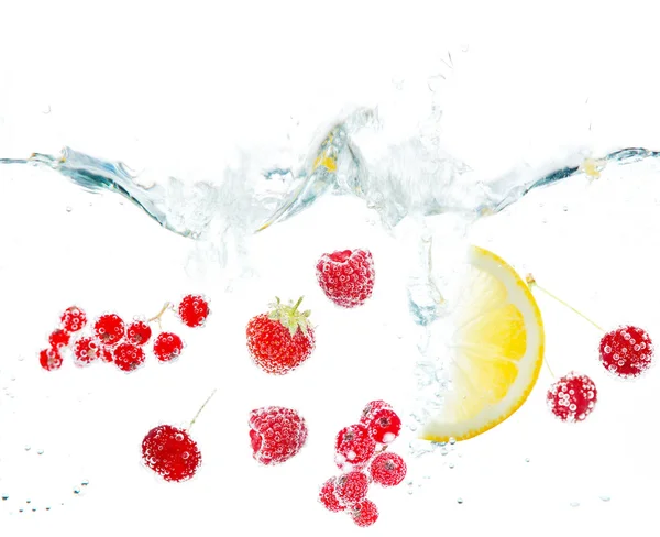 Frutas e bagas frescas salpicando na água isolada no branco — Fotografia de Stock